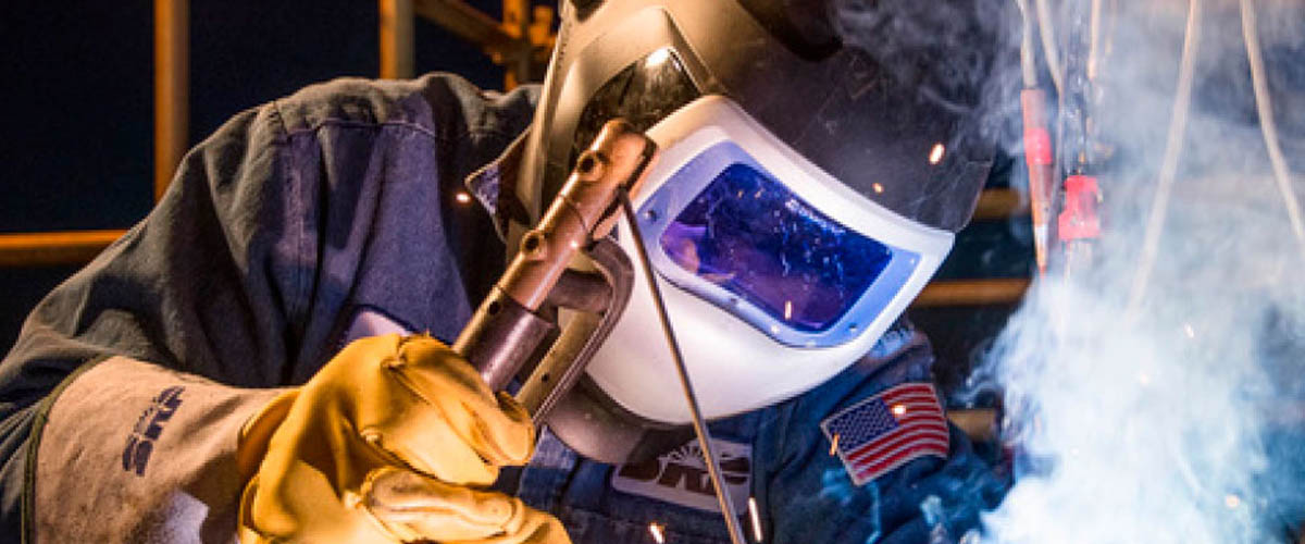 A welding specialist working in the field of advanced manufacturing. Information panels (could be used for all if necessary): A printed circuit board assembly in process.