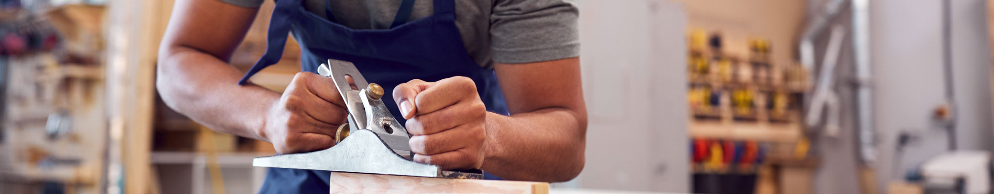  A craftsman uses a hand plane to shape a piece of wood.