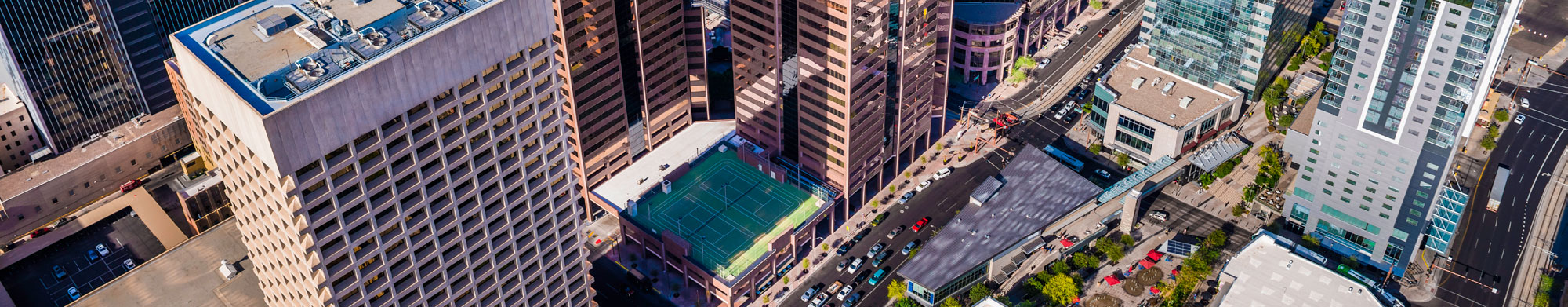 Aerial view of large buildings in downtown Phoenix, including a rooftop tennis court.