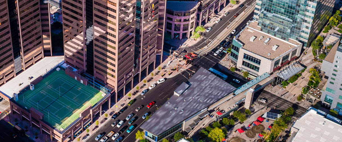 Aerial view of large buildings in downtown Phoenix, including a rooftop tennis court.