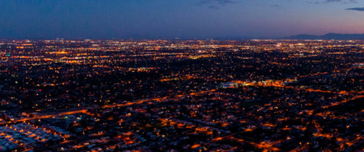 Aerial image of Phoenix at night, with a view of the freeways and roads lit up in the dark.